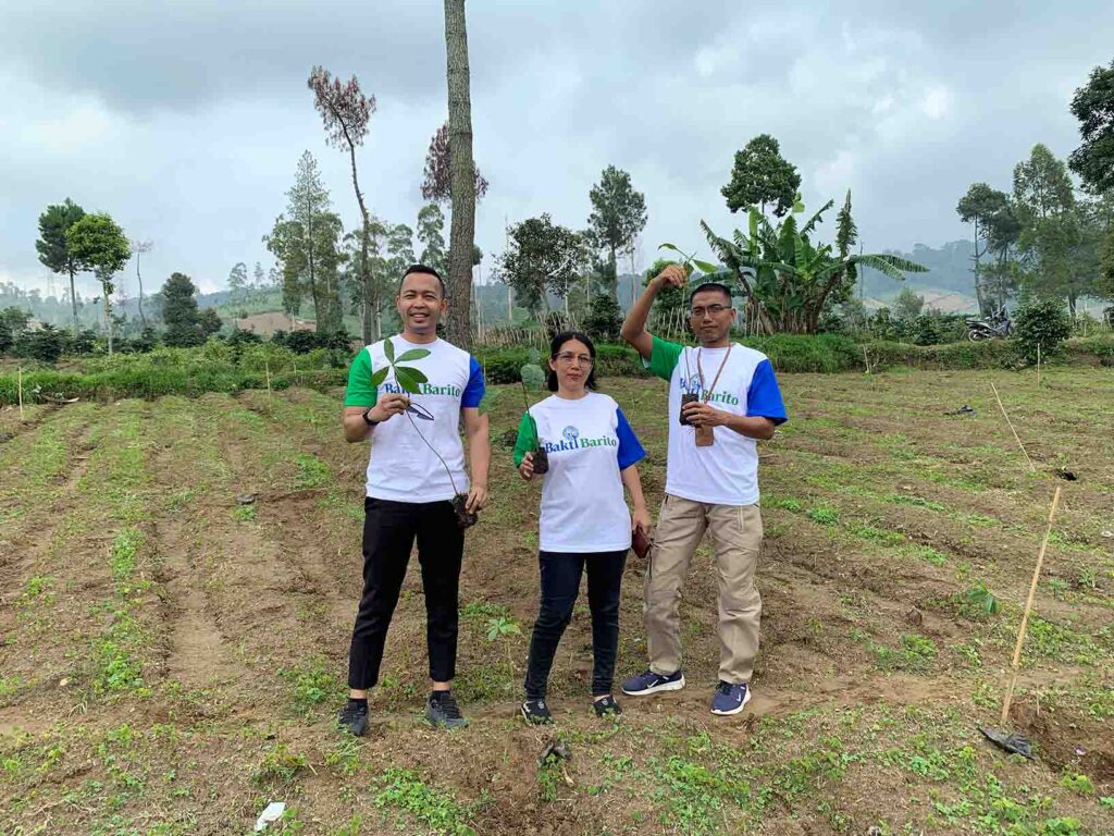 Bakti Barito Green Guardians Program: Program Manager Rinaldi Simatupang, Field Coordinator of Bakti Barito Rismayanti Priyanita, and Government Relations of Bakti Barito Yoris Sunarjan, stand holding tree saplings during Star Energy Geothermal's military tree planting event in Garut Regency.