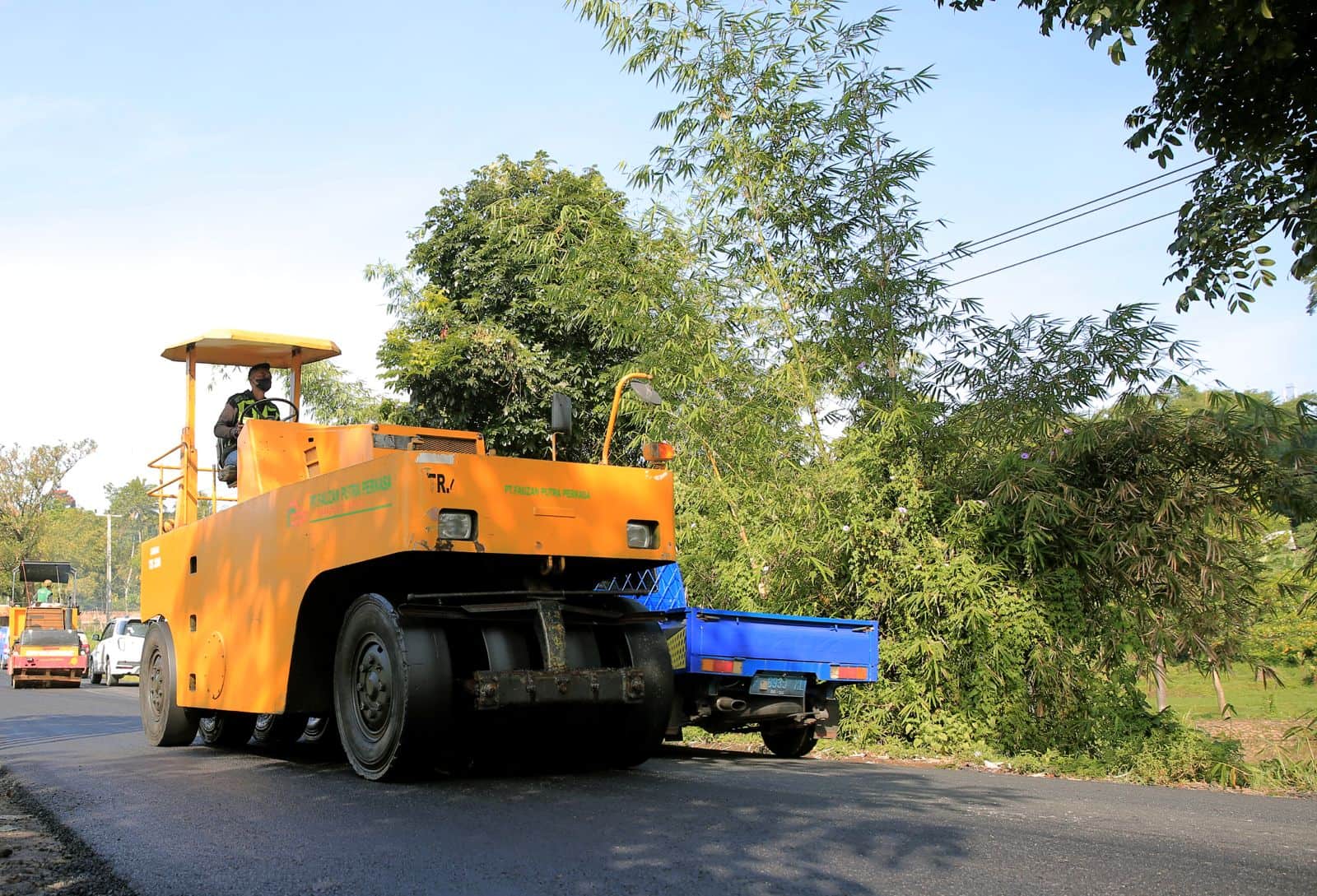 A road construction machine laying asphalt, as part of a program using recycled plastic