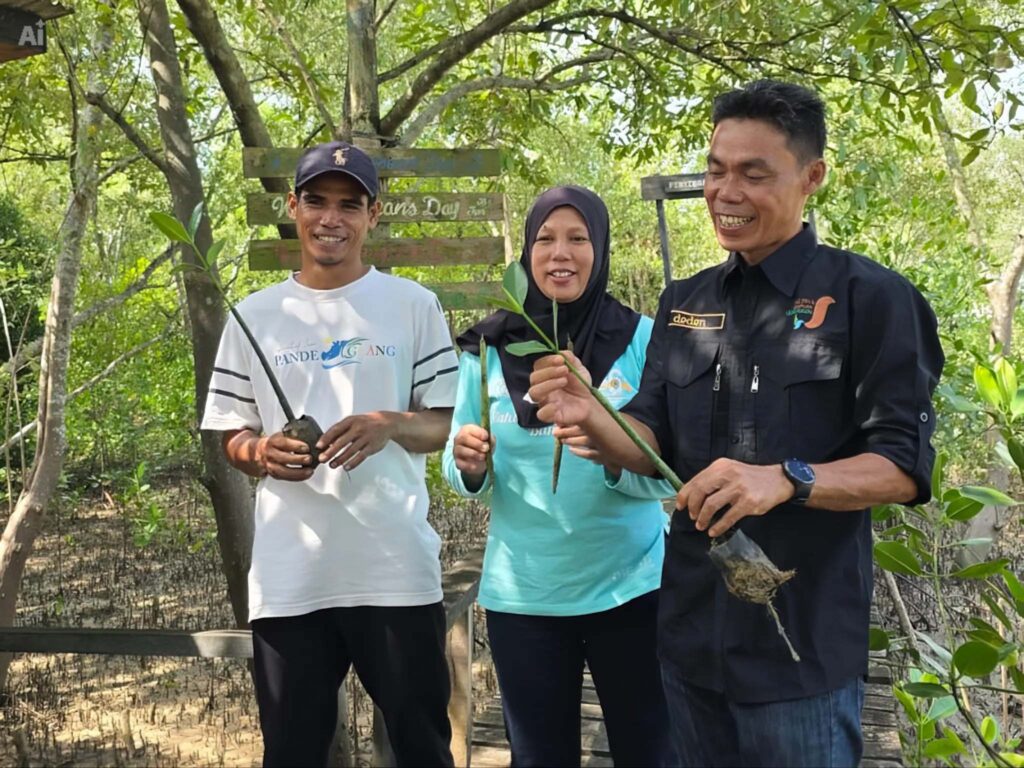 Chandra Asri Group Edu-Ecotourism Mangrove Progam: Three field officers holding mangrove seedlings in the Lembur Patikang area.